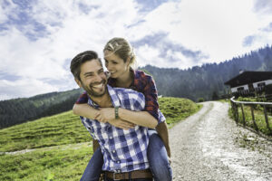 Woman riding piggyback on man, Tirol, Austria